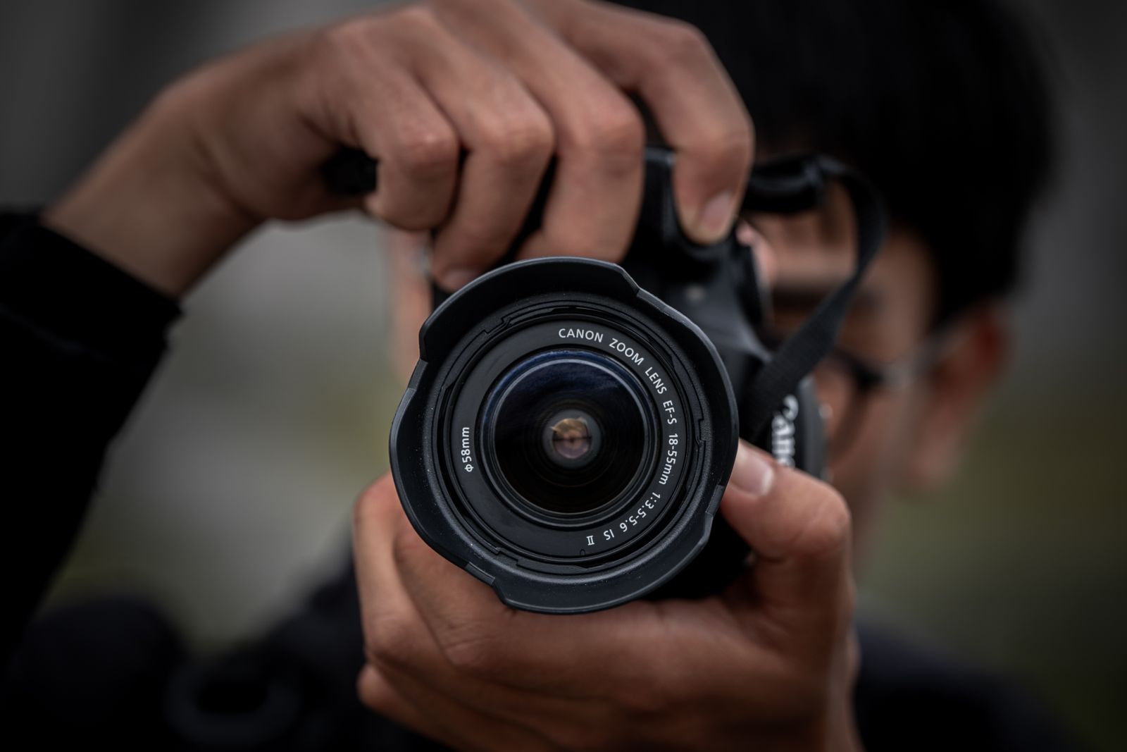 Close-up of a DSLR lens aimed straight at the frame