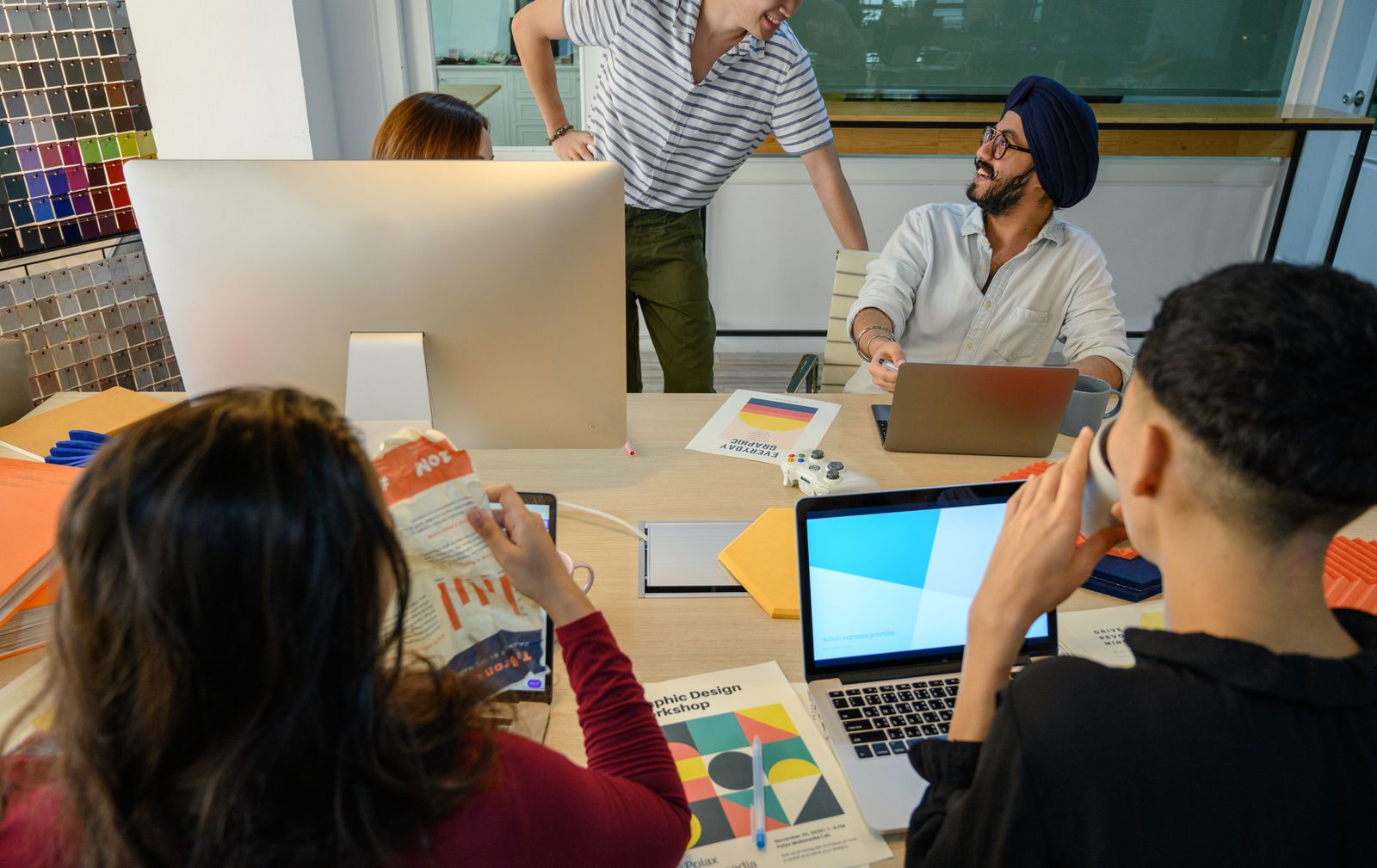 A design team reviewing layouts with color samples on the desk