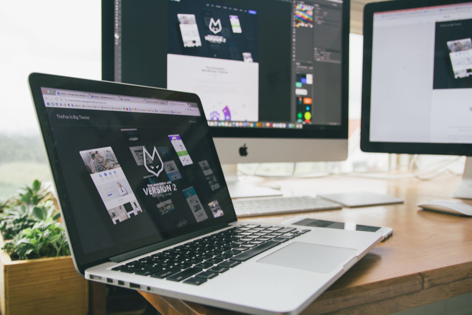 A web designer's workstation with two screens — image optimization speeds up loading
