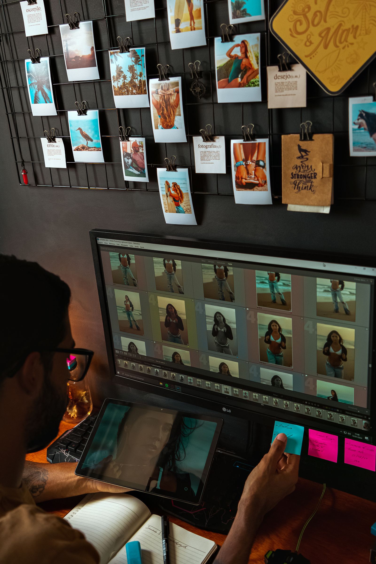 A designer at a large monitor reviewing a grid of many shots before export