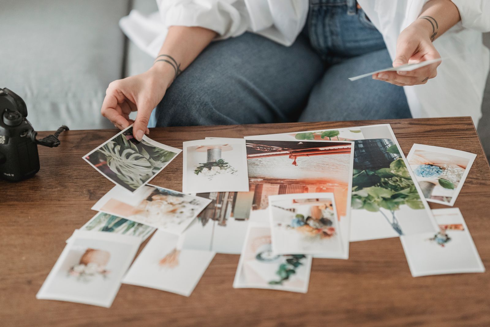 A woman sorting through printed photos on a table