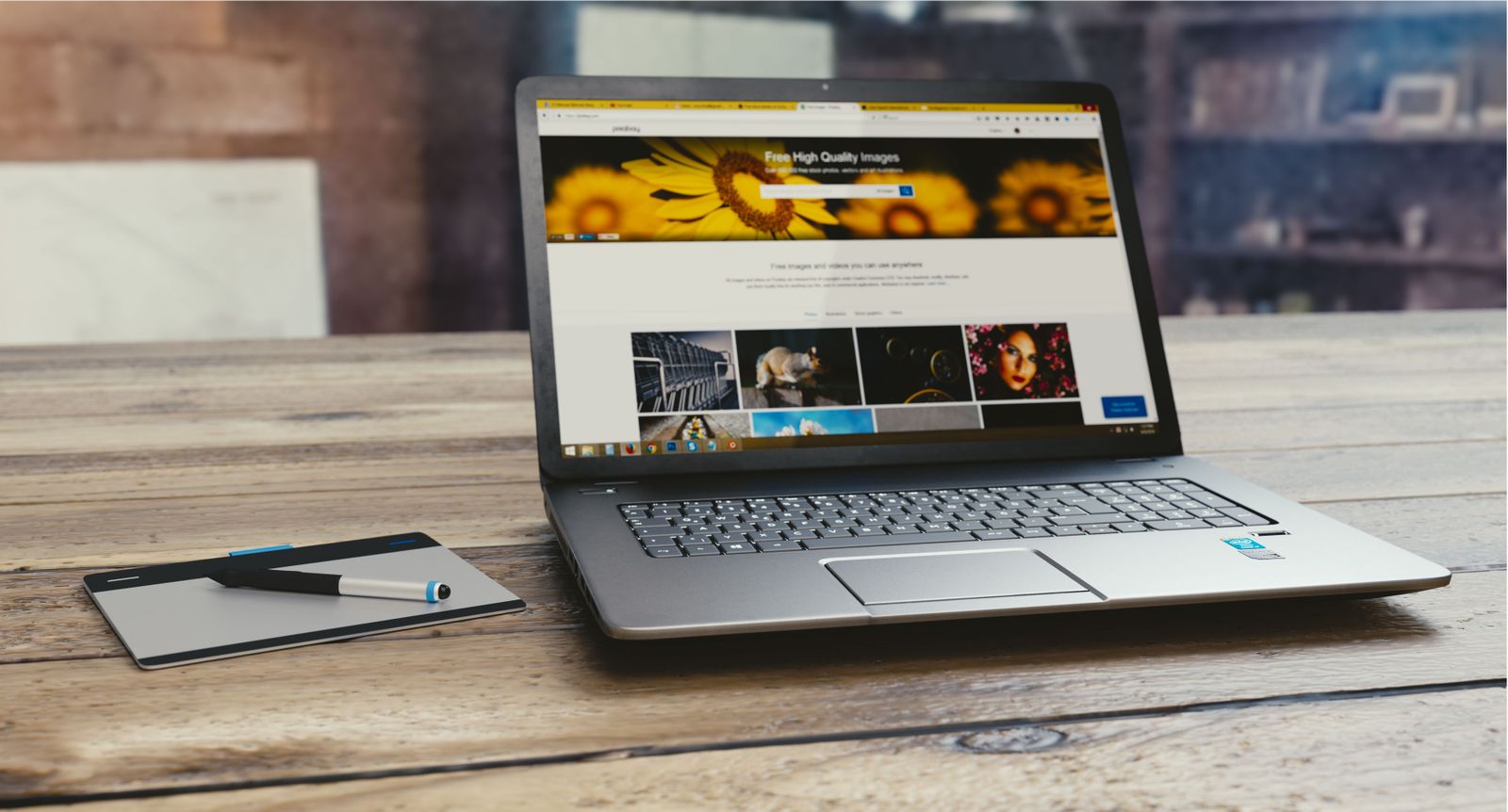 A laptop showing a gallery website with graphic elements