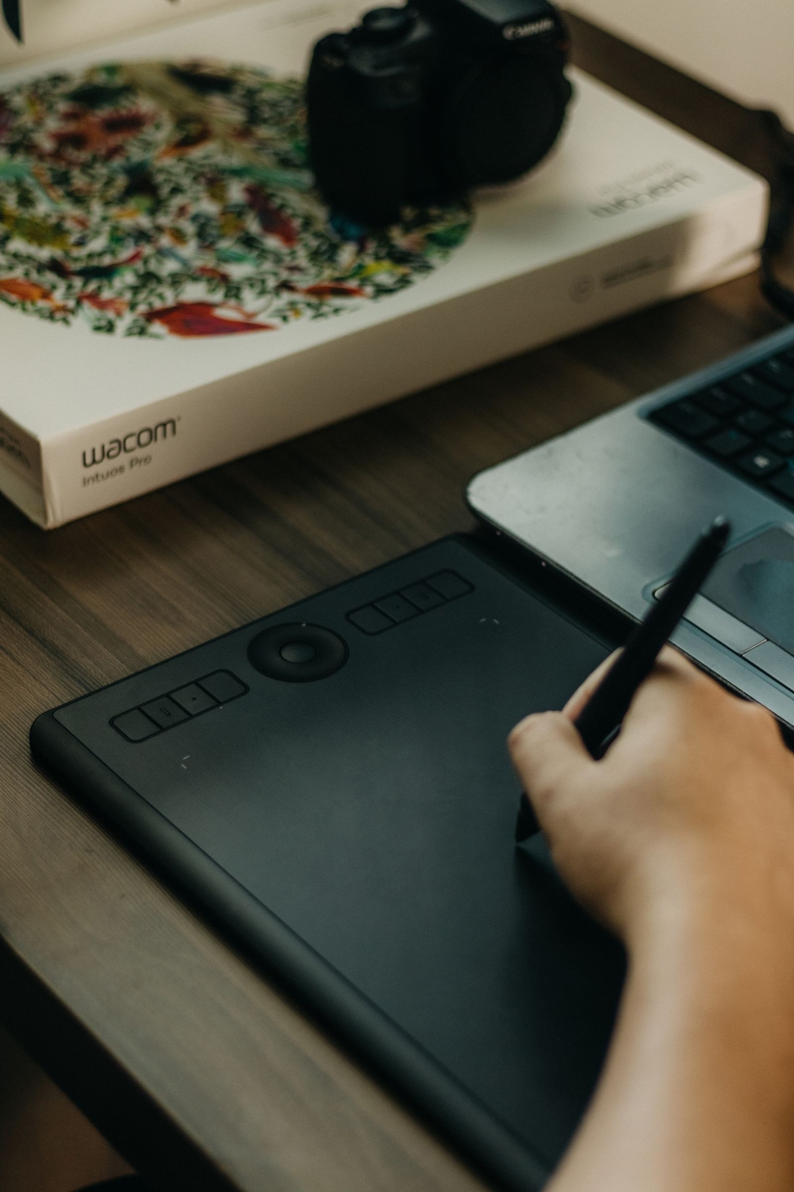 Коробка графического планшета Wacom Intuos Pro, сам планшет и ноутбук на столе — рабочее место для редактирования XCF